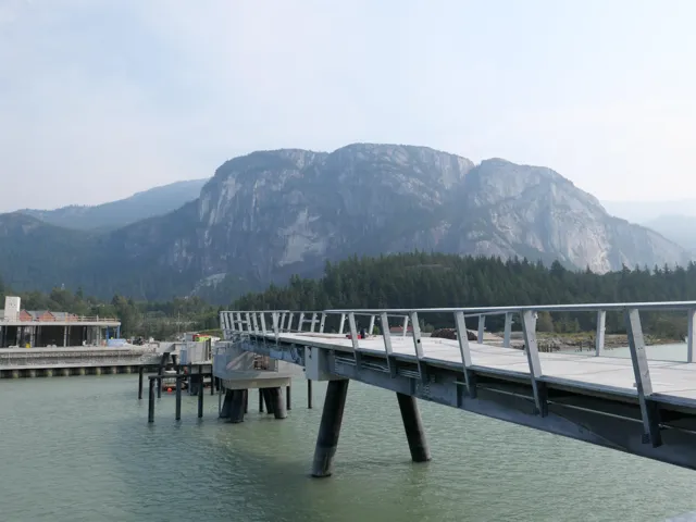 Dock area with a wooded view and a water and mountain view