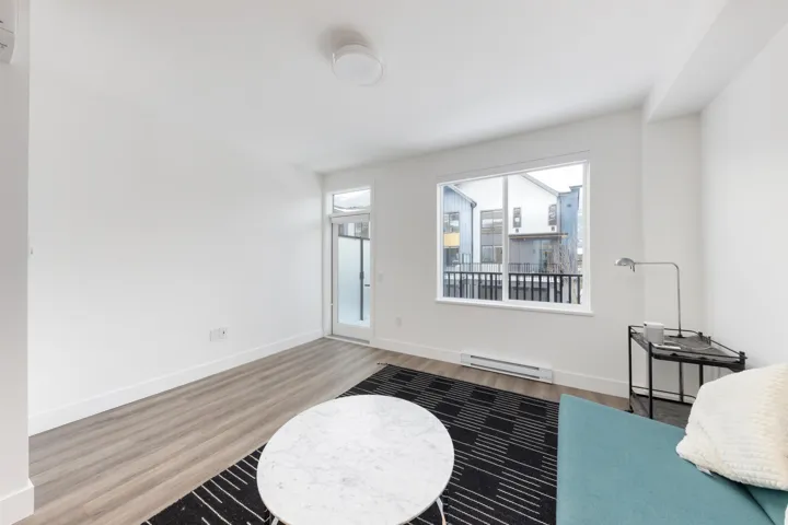 Interior space with wood finished floors, baseboards, and baseboard heating
