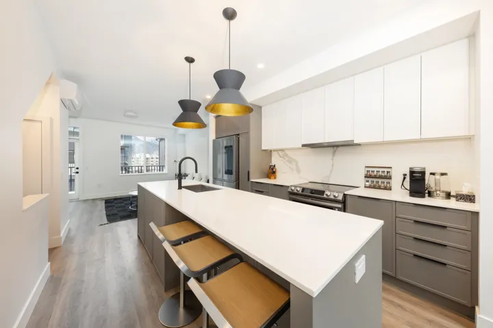 Kitchen with a wall unit AC, a sink, stainless steel appliances, and gray cabinets