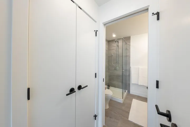 Full bathroom featuring a stall shower, wood finished floors, and toilet