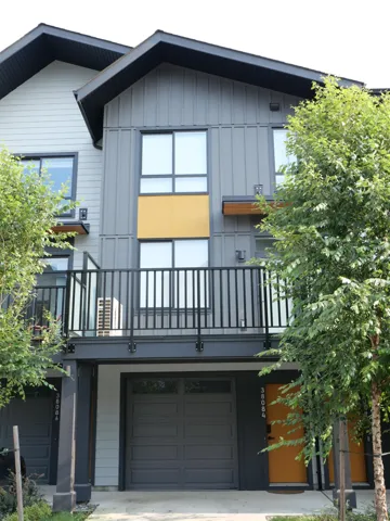 View of front of property with a balcony, board and batten siding, and a garage
