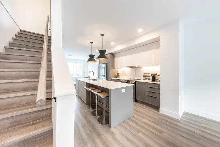 Kitchen with a sink, a breakfast bar, modern cabinets, a center island with sink, and stainless steel appliances