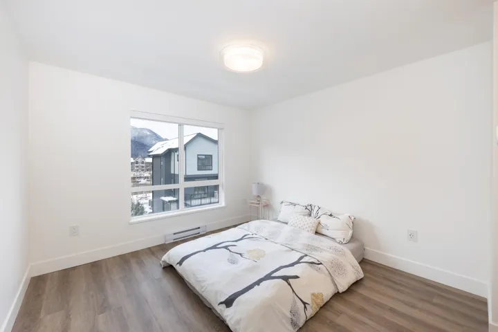Bedroom featuring baseboards, baseboard heating, and wood finished floors