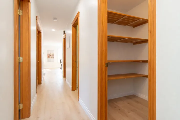 Hall with light wood-style flooring and recessed lighting