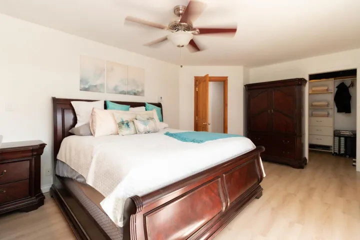 Bedroom with light wood finished floors, a ceiling fan, and a closet