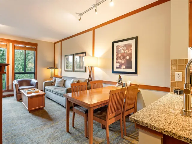 Dining space with rail lighting and dark colored carpet