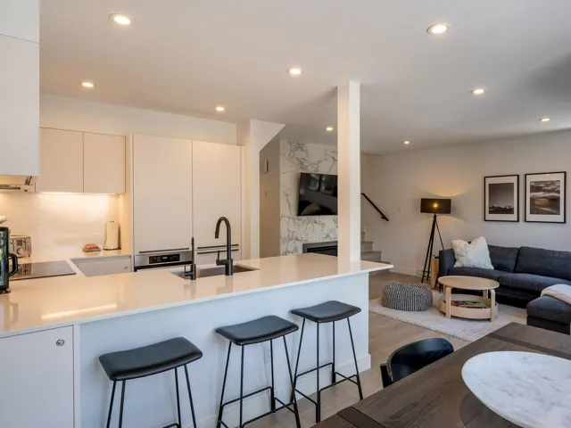 Kitchen with open floor plan, a peninsula, a kitchen breakfast bar, and recessed lighting