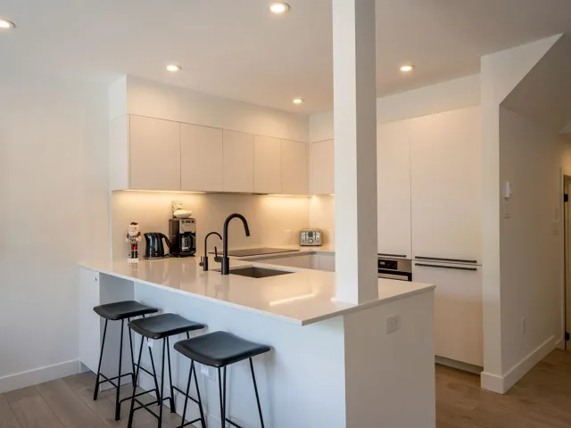 Kitchen featuring a sink, a peninsula, a breakfast bar area, and modern cabinets