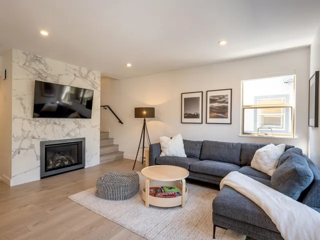 Living area with stairs, a premium fireplace, wood finished floors, and recessed lighting