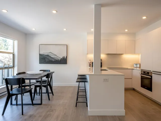 Kitchen featuring oven, white cabinets, light wood-style floors, a kitchen breakfast bar, and modern cabinets
