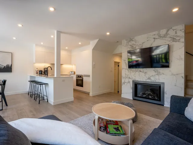 Living room featuring light wood-style floors, a high end fireplace, and recessed lighting
