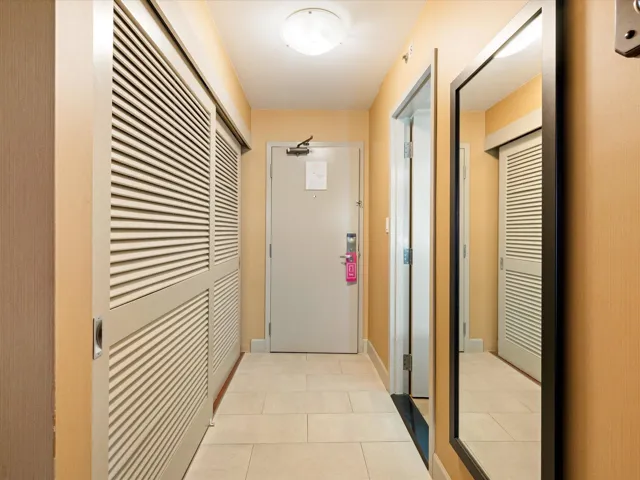 Corridor with light tile patterned flooring and baseboards