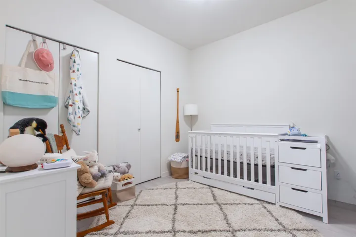 Bedroom with a nursery area and wood finished floors