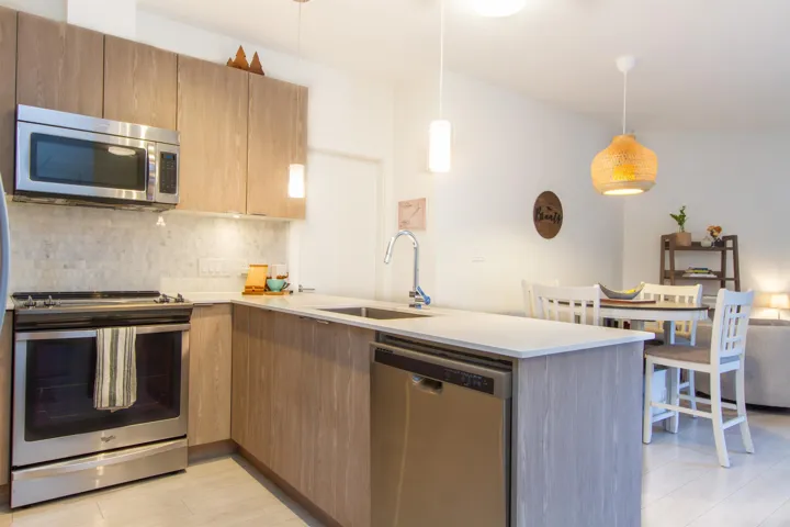 Kitchen featuring tasteful backsplash, a peninsula, stainless steel appliances, light countertops, and a sink