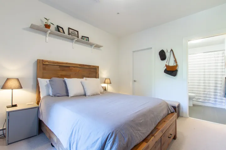 Carpeted bedroom featuring ensuite bath