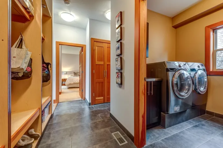 Washroom with independent washer and dryer and dark tile patterned floors