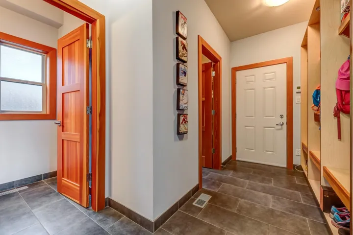 Hall with dark tile patterned flooring and baseboards