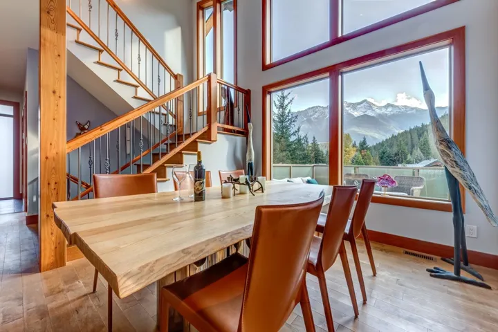 Dining space featuring a mountain view, stairs, a towering ceiling, and wood finished floors