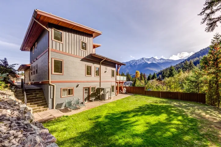 Back of house featuring board and batten siding, a patio area, stairs, and a mountain view