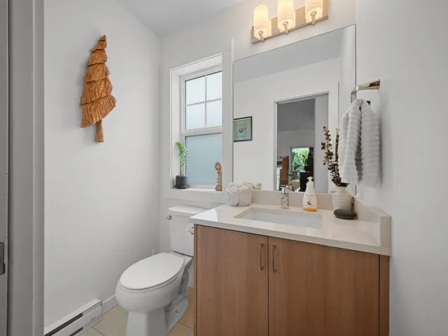 Bathroom featuring a wood-finish vanity with an integrated sink and light-toned countertop