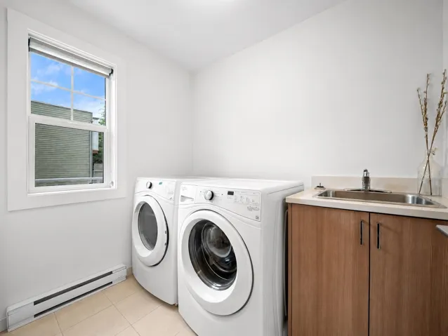 Dedicated laundry area featuring a utility sink with a stainless steel faucet, wood-finish cabinetry, and a beige countertop