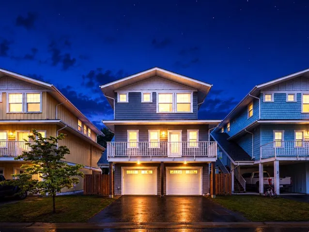 Contemporary multi-story residence featuring a two-car garage, upper-level balcony, and gabled roofline