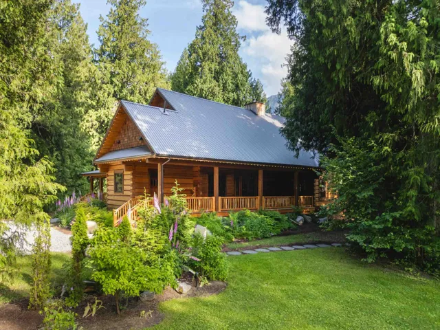 Back of house with a porch, a lawn, a chimney, and metal roof