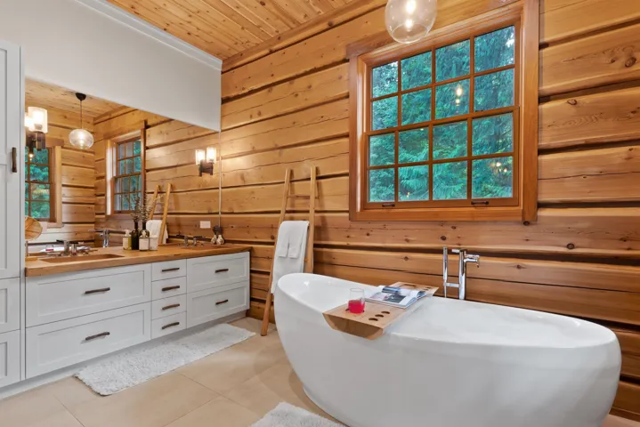 Bathroom with double vanity, tile patterned floors, wooden walls, and wooden ceiling