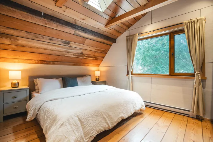Bedroom featuring wood-type flooring, a baseboard heating unit, wood ceiling, and lofted ceiling with skylight