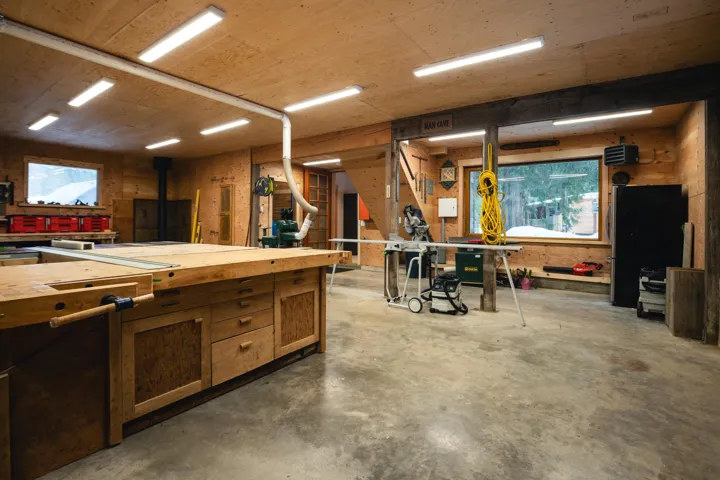 Interior space with a workshop area and a wood stove