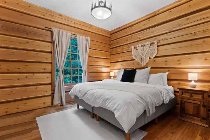 Bedroom with wood-type flooring and wooden walls