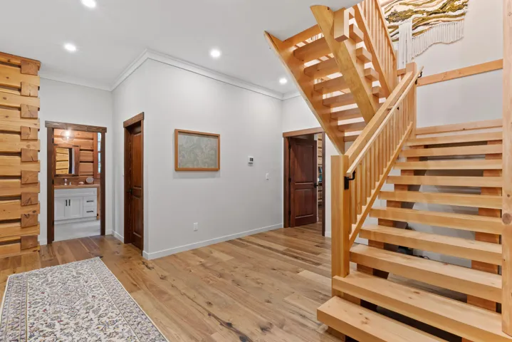 Stairs featuring crown molding, baseboards, recessed lighting, and wood finished floors