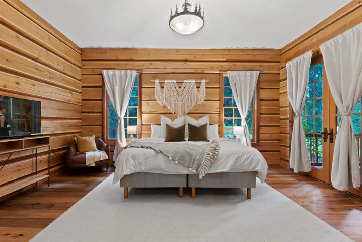 Bedroom featuring a chandelier, wood finished floors, and wooden walls