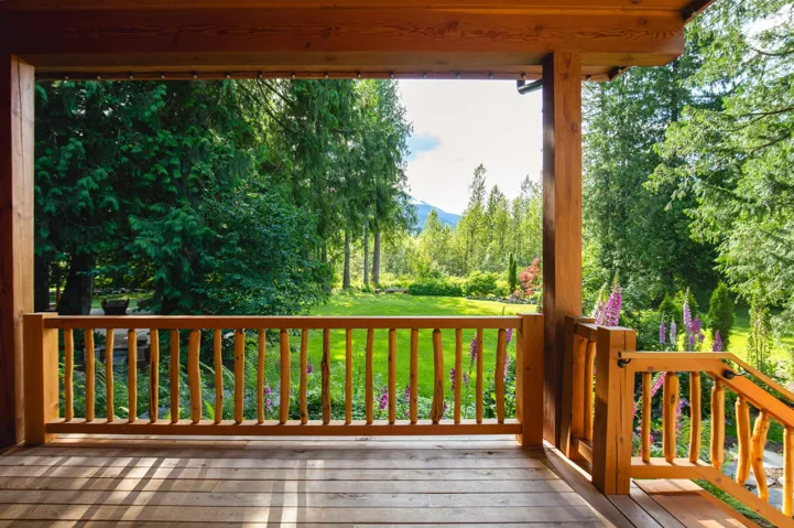Wooden deck featuring a lawn and a mountain view