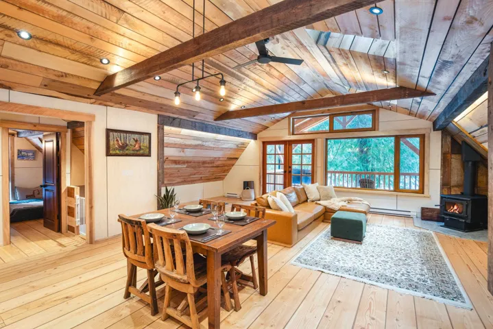 Dining room with a wood stove, baseboard heating, wooden ceiling, and hardwood / wood-style floors