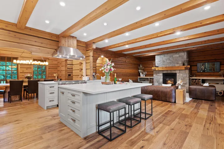 Kitchen featuring light wood-style floors, a large island with sink, and beam ceiling