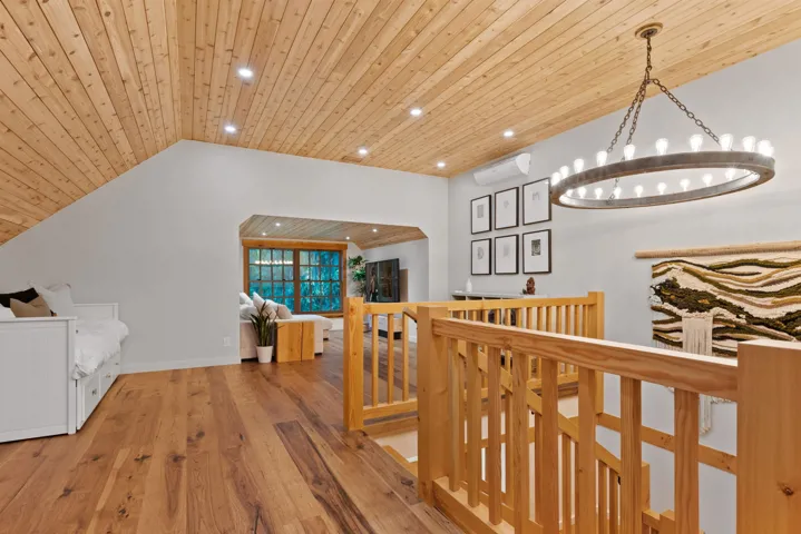 Hallway with wood finished floors, recessed lighting, wood ceiling, a notable chandelier, and an upstairs landing
