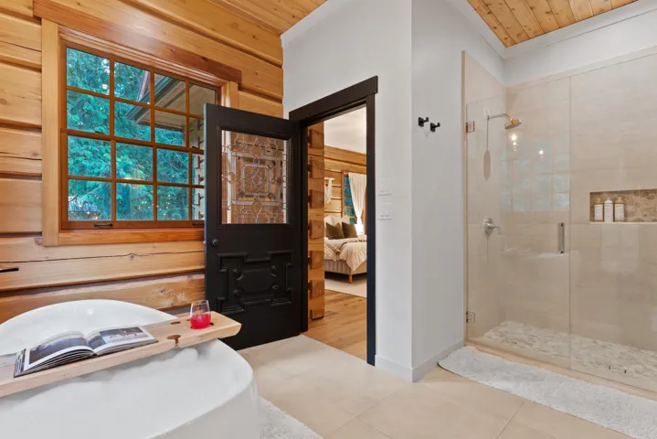 Ensuite bathroom with tile patterned floors, a shower stall, wood ceiling, and connected bathroom