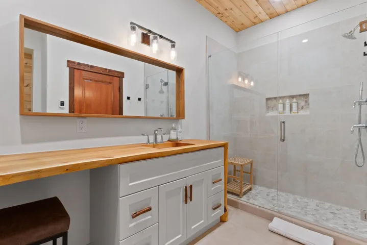 Full bath featuring vanity, tile patterned floors, and a shower stall