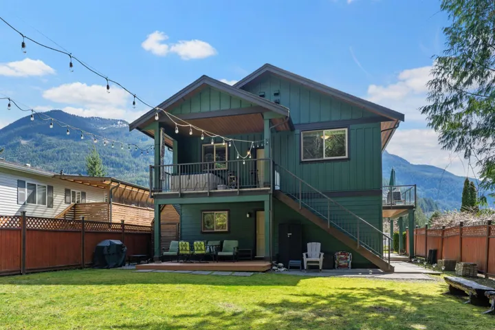 Rear view of property with a deck with mountain view, board and batten siding, and a patio