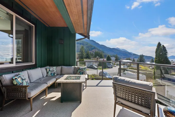 Front corner patio overlooking Howe Sound, featuring an outdoor living space with a fire pit and area for grilling