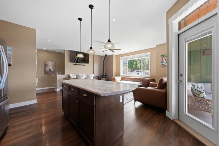 Kitchen featuring light countertops, open floor plan, pendant lighting, and wood finish cabinets