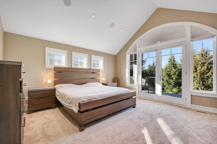 Luxury primary bedroom with fireplace and covered private balcony.