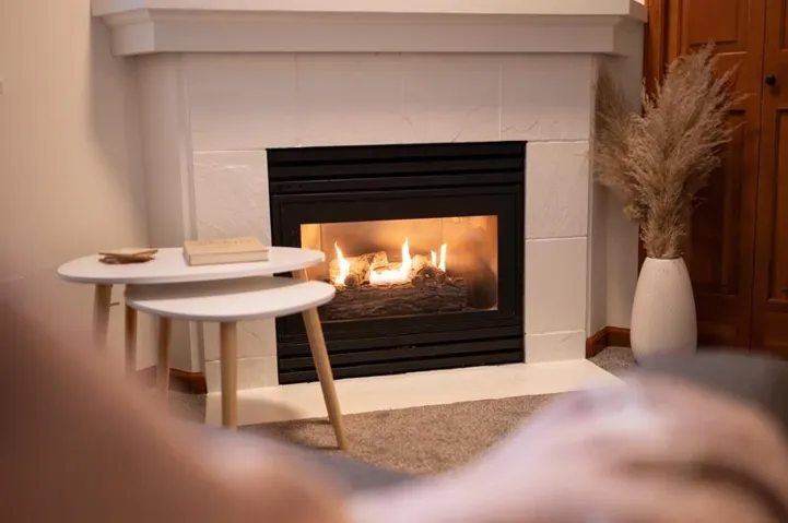 Fireplace featuring a stone-look surround and hearth, with a substantial mantel