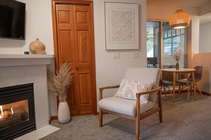 Fireplace with a white mantle, wood-finish bi-fold doors, and a sliding glass door