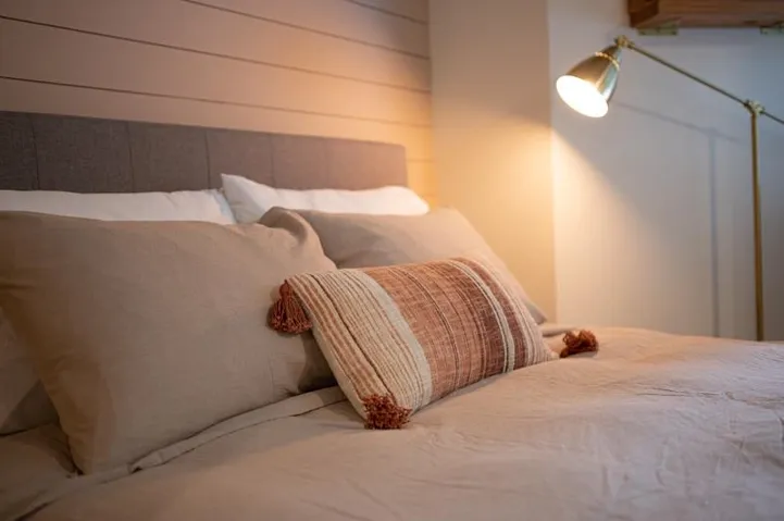 Fabric upholstered headboard against a shiplap accent wall
