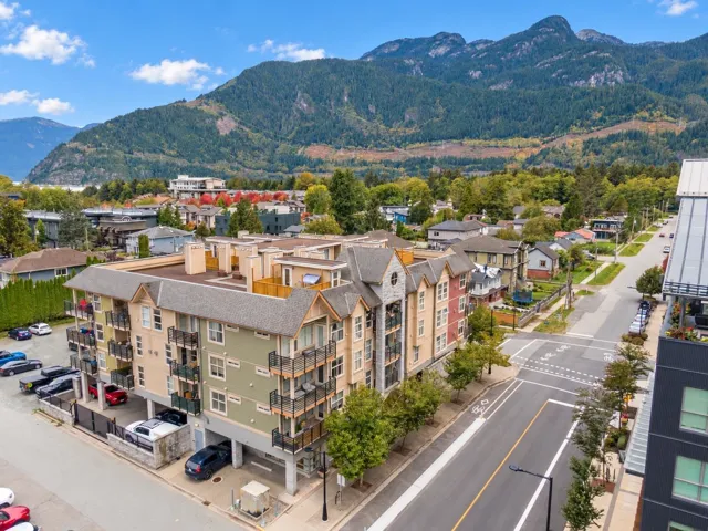 Multi-story residential building with private balconies and surface parking