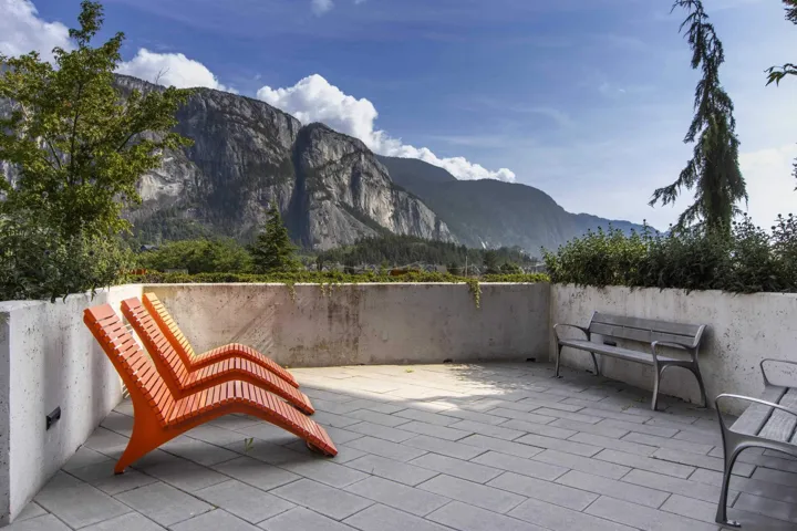 Paved outdoor terrace with concrete retaining walls and integrated planters