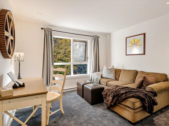 Carpeted living area featuring recessed lighting and baseboard heating
