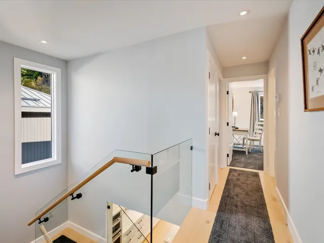 Hall with recessed lighting, an upstairs landing, light wood-style flooring, and baseboards